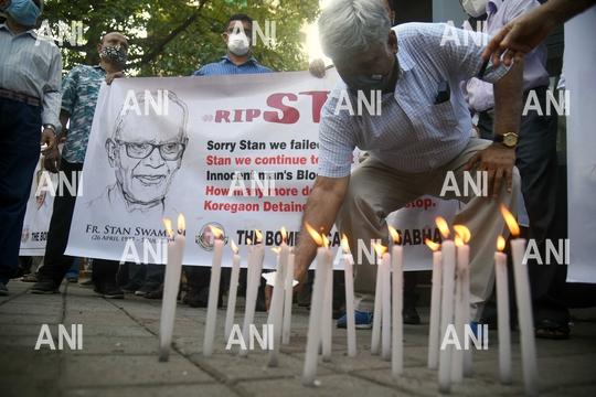 People lighting the candle during a prayer meeting for Father Stan Swamy outside a church, in Mumbai on Tuesday
