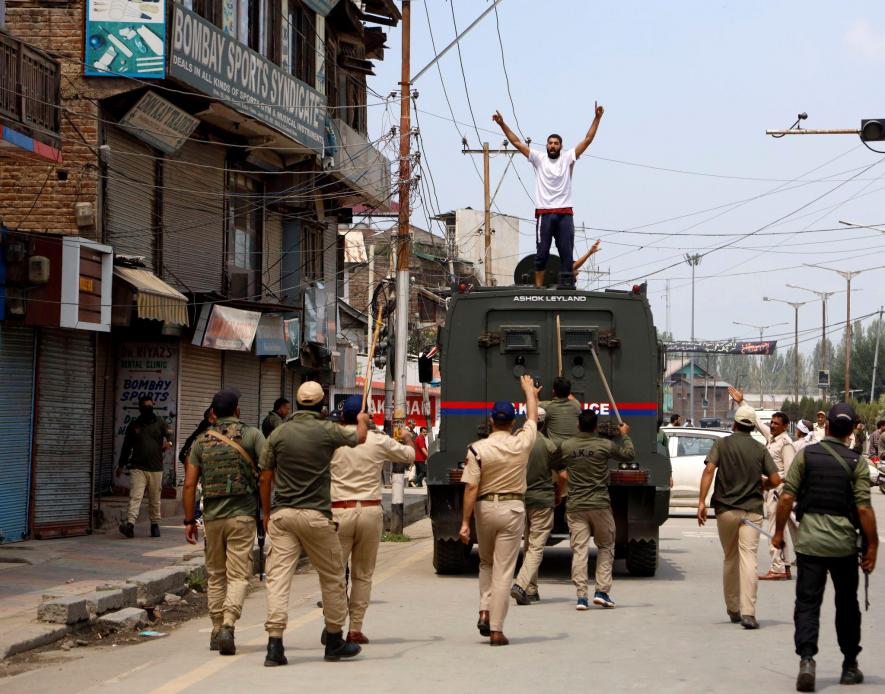 A detained mourner climbs atop a police van raising Hussaini slogans at Srinagar
