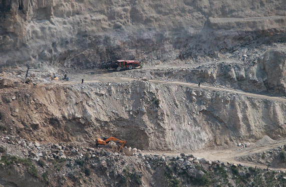 Excavators dig through mountains to make roads for under-construction hydropower projects in Kishtwar.
