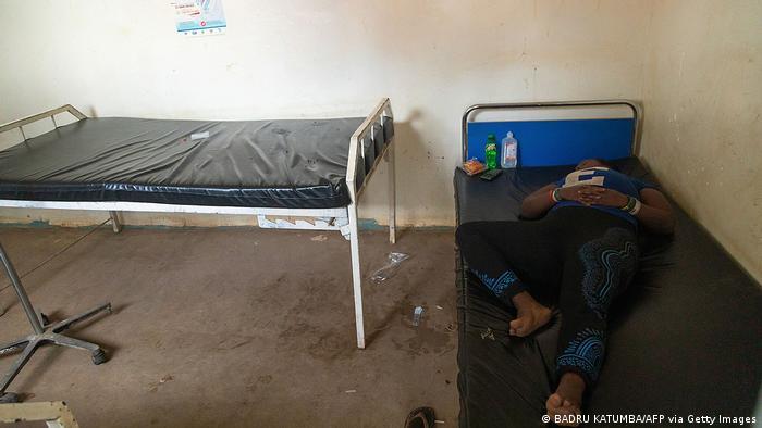 A suspected Ebola patient rests on the bed at Madudu Health center 3, waiting to be transferred to an isolation unit in Mubende, Uganda