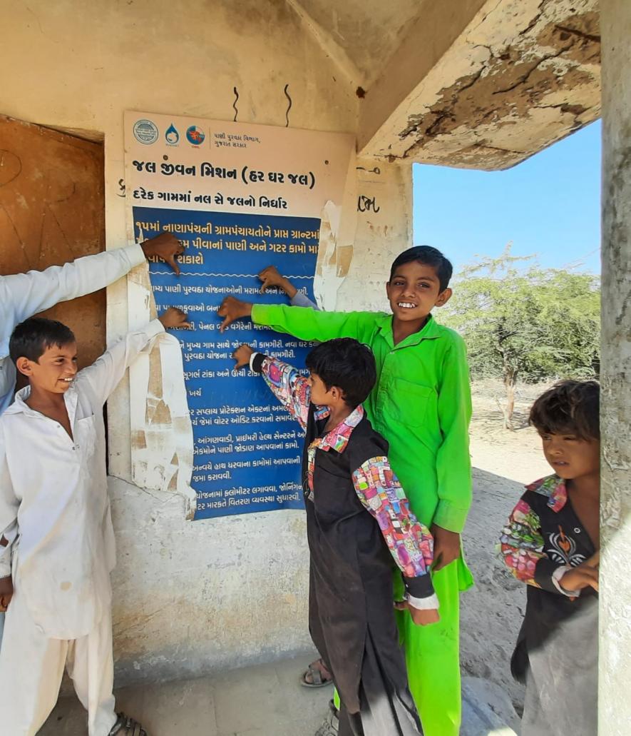 Kids at Udai village explaining how the 'Har Ghar Nal' Yojana was restricted to the Board intact outside their Panchayat office. There is not a single tap connection in their village.