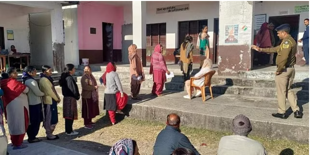 Voters wait in a queue to cast their votes for the Himachal Pradesh Assembly elections, at a polling station in Dharamshala district