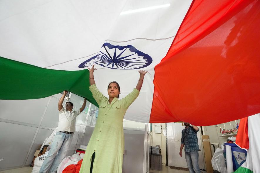 Workers hold a huge Indian flag at a workshop ahead of the Republic day, in Mumbai, Wednesday, Jan. 18, 2023