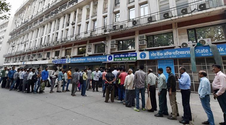 People queue up at out side of banks ATM to get money in New Delhi. 