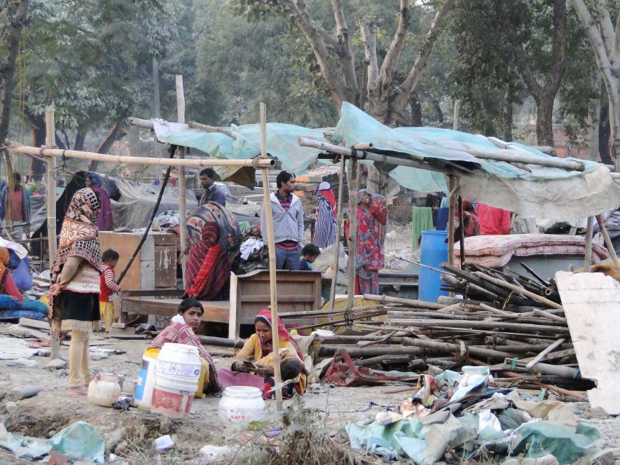 People collect their belongings after a demolition drive carried out by the railways in Shakur Basti of Delhi on Sunday.