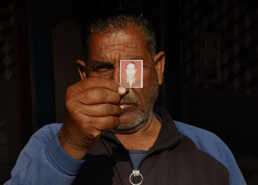 The victim Satish's father, Sat Paul Sharma, proudly exhibits a photo of his son in Dangri village in the Rajouri area of Jammu(Photo by Kamran Yousuf).