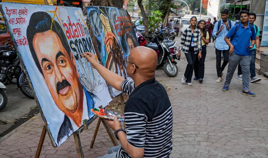 An artist gives final touches to a painting of businessman Gautam Adani highlighting the ongoing crises of the Adani Group, in Mumbai, Friday, Feb. 3, 2023.