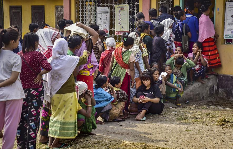 Voters wait in queues to cast their votes at a polling booth during the Meghalaya Assembly elections, in Ri Bhoi district, Monday, Feb. 27, 2023.