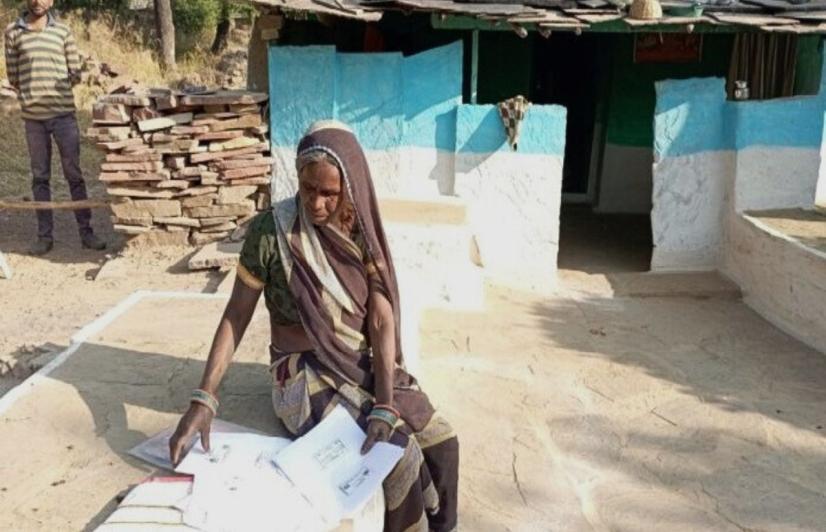 woman from Badwani examines her IFR papers (Photo sourced by Sanavver Shafi, 101Reporters)