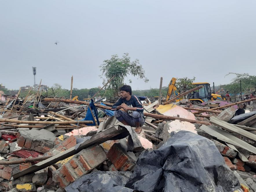 Suresh, the younger sibling sitting on top of all the debris and staring into nothing