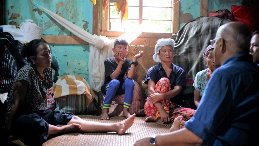 Family members of a paralyzed woman rescued during the violence sharing their ordeal at the Kholum Church Relief Camp, Churachandpur/Lamka