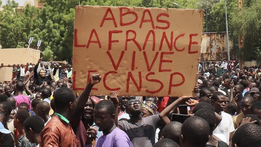 Protesters with sign that reads: Down with France, long live the CNSP (National Council for the Safeguard of the Homeland).