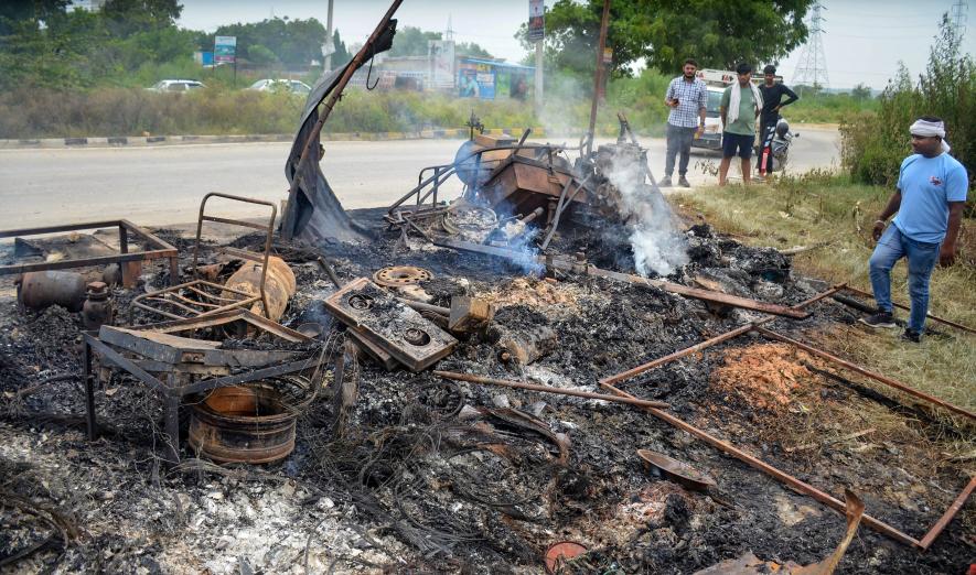 Locals look at burnt items at a shop which was set ablaze in a fresh case of communal violence in Gurgaon.