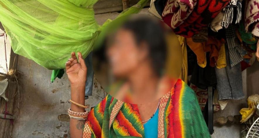 Meena Devi sits on her charpai, pointing at the mosquito net above (Photo – Saumya Kalia)