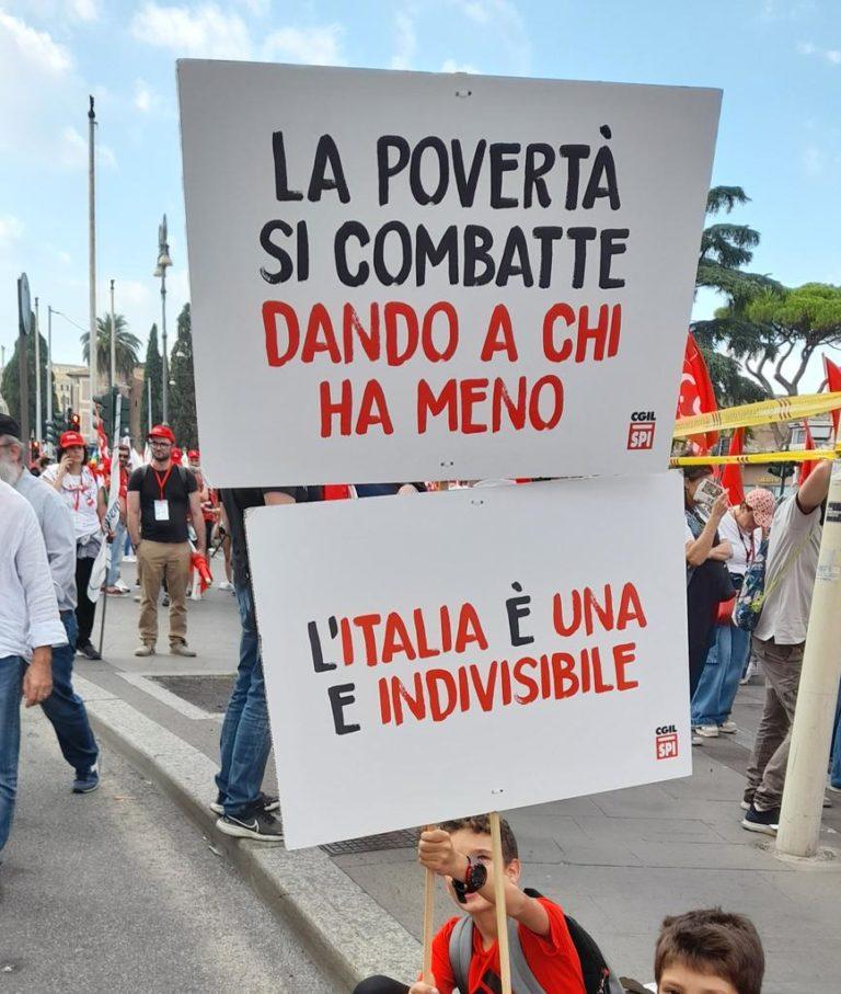 Young protesters holding a sign reading “Poverty is confronted by sharing with who has less: Italy is indivisible”