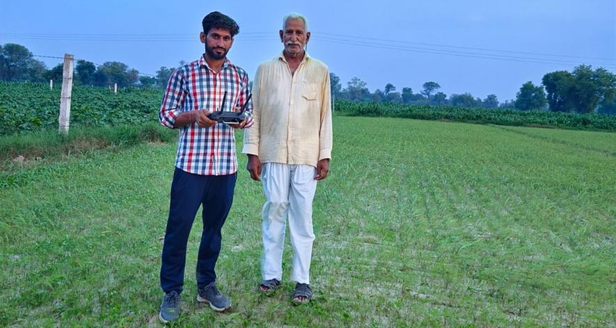 Ashish Beniwal spraying pesticides with a drone in a field in a village in Hanumangarh district (Photo sourced by Amarpal Singh Verma, 101Reporters).