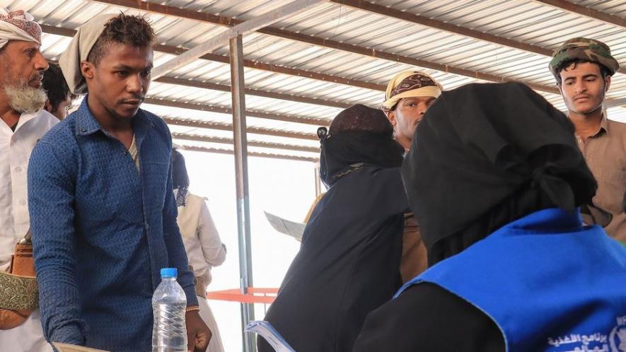 Beneficiaries queue at a WFP food distribution point in Yemen in November 2023. (Photo: Jihad Al-Nahari/WFP)