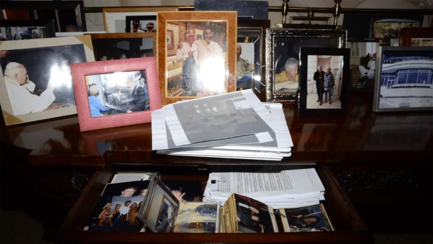 Desk drawer with printed pictures including Donald Trump with Jeffrey Epstein and Ghislaine Maxwell and Trump standing with women in swimwear. Photo: DOJ